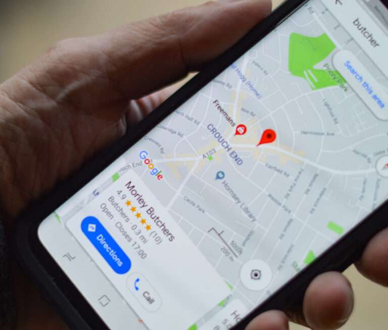 A hand holds a smartphone displaying a Google Maps search for a butcher shop, with the location marked and directions button visible, highlighting how seo software can help local businesses appear in search results.