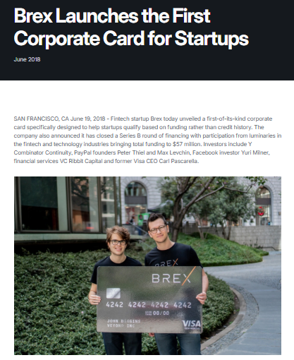 A man holds a Brex corporate card in front of a laptop displaying the Brex logo at a business event or launch presentation.